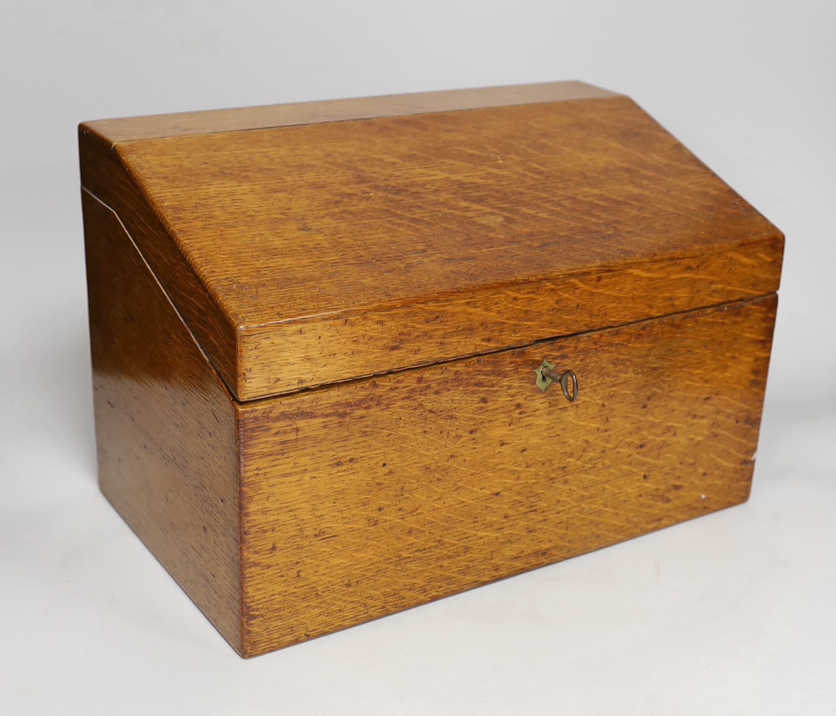 A 19th century oak stationery casket, with a sectional fitted interior and leather compartment for pens, 1d stamps and 2d stamps, 36.5cms wide x 24cms high